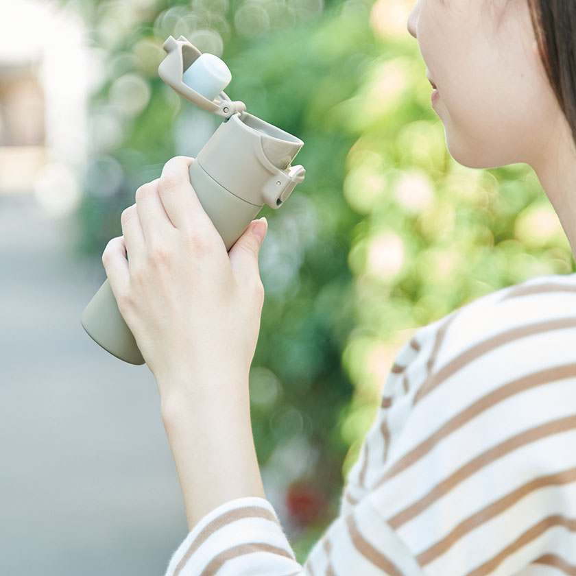 片手で飲めるワンタッチミニボトル140mlを手に持ったイメージ
