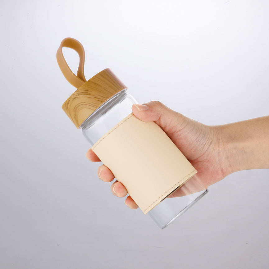 ウッドスタイル耐熱ガラスボトル（カバー付きを手に持った写真